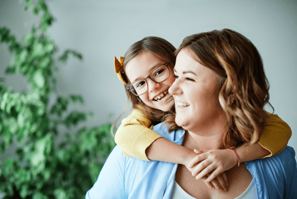Happy woman giving child a piggy-back ride