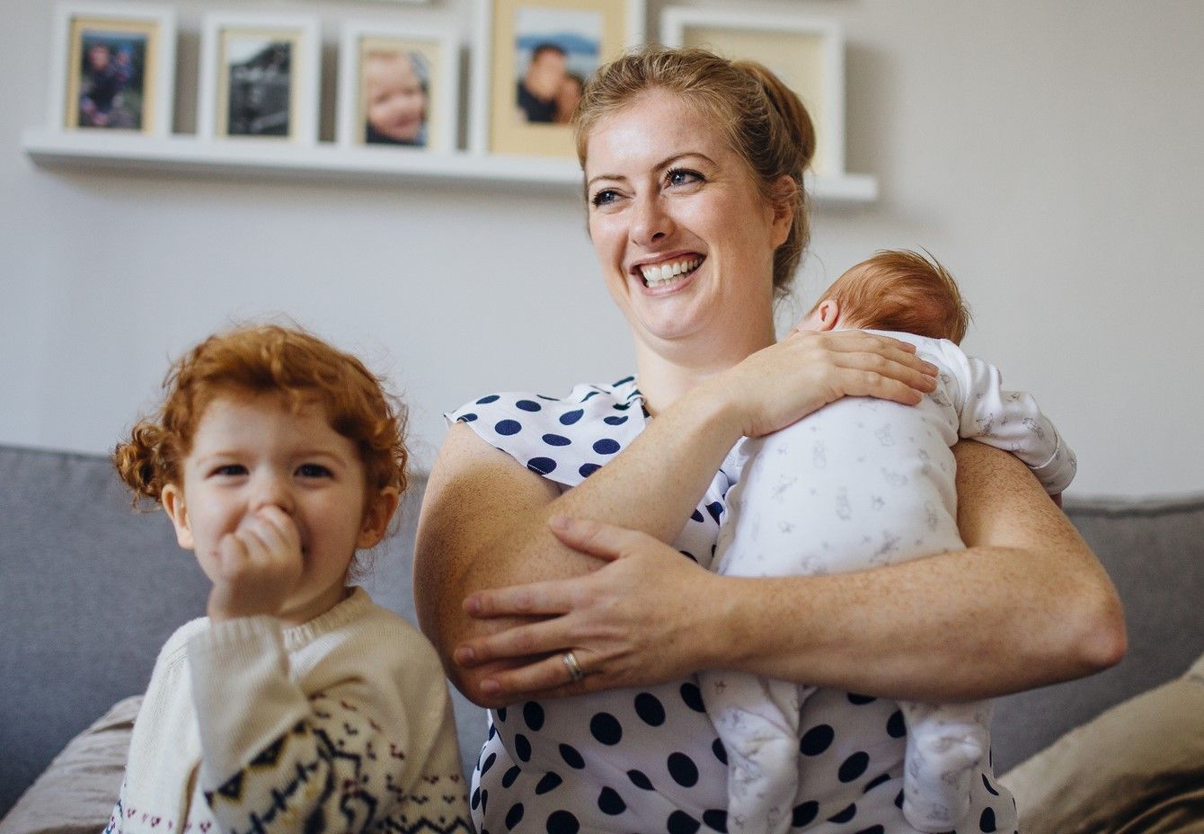 Happy woman holding a baby with happy child
