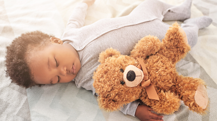 Baby sleeping with a teddy bear