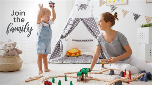 Childcarer and child playing with a wooden train set
