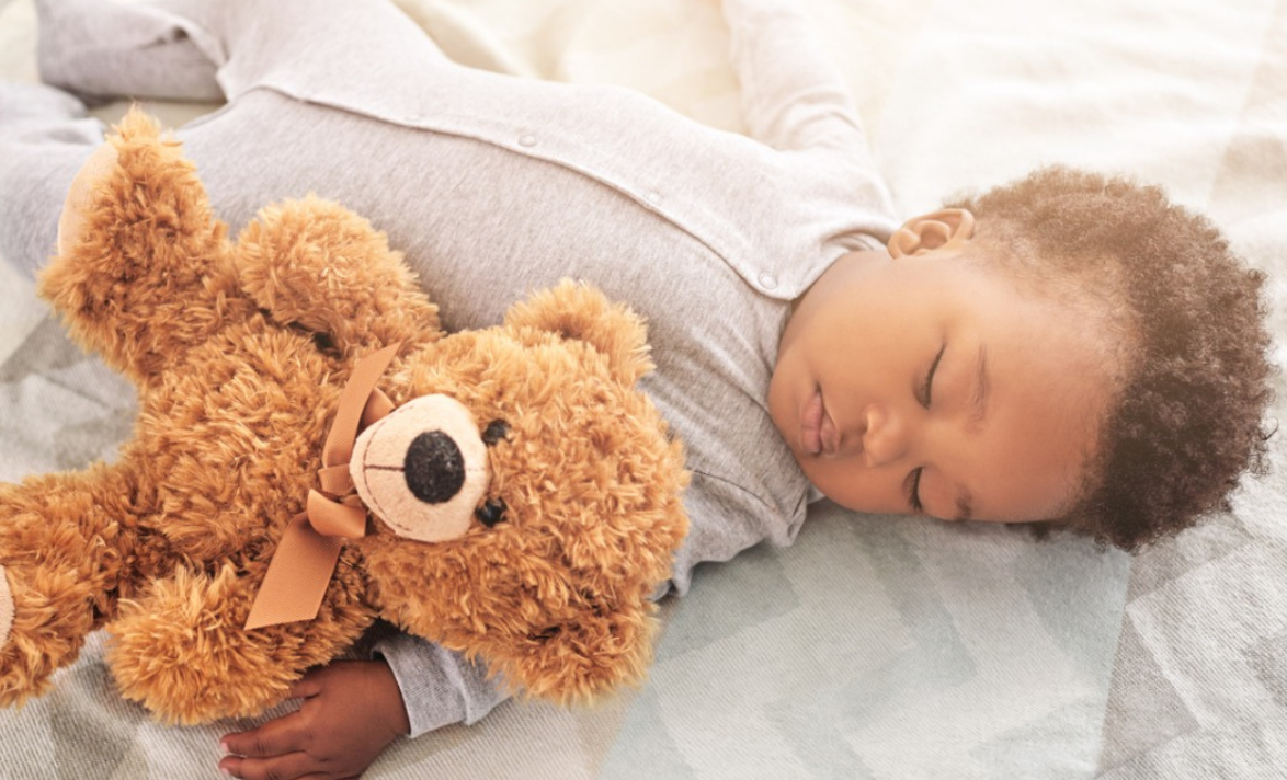 Peacefully sleeping baby with teddy bear