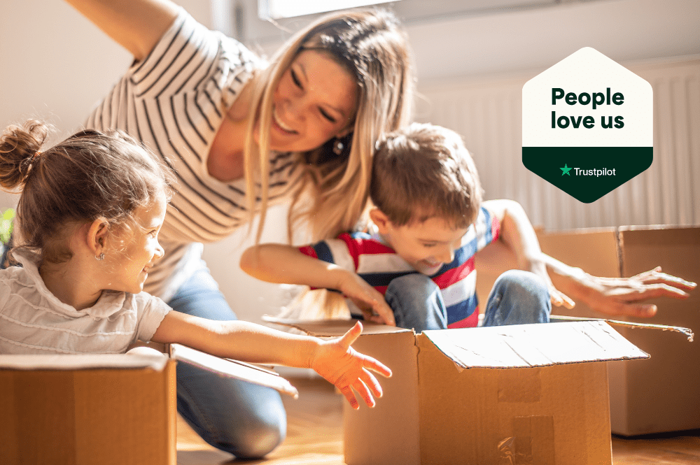 Happy woman with two children playing together with cardboard boxes